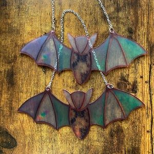 Two Halloween stain glass style bats. Made out a plastic material not glass.